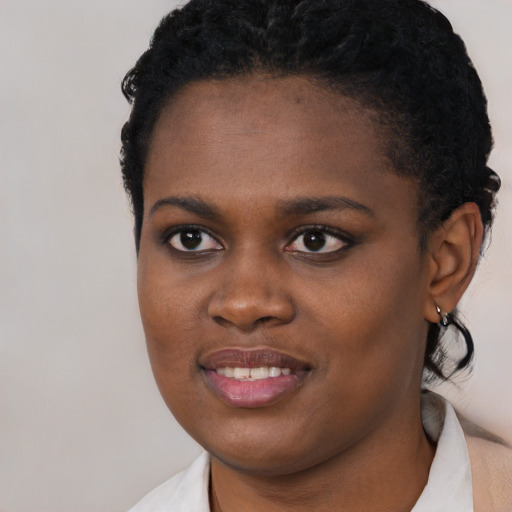 Joyful black young-adult female with short  brown hair and brown eyes