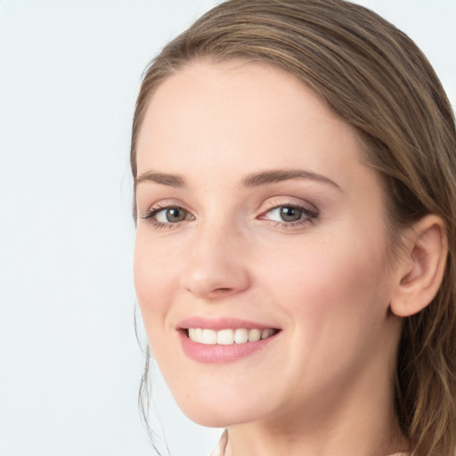 Joyful white young-adult female with long  brown hair and blue eyes