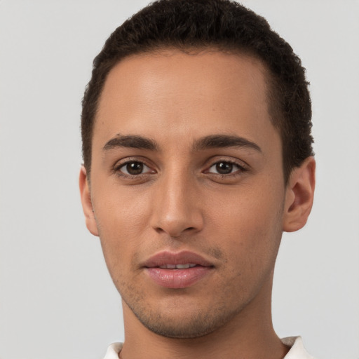 Joyful latino young-adult male with short  brown hair and brown eyes