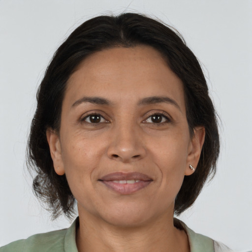 Joyful latino adult female with medium  brown hair and brown eyes