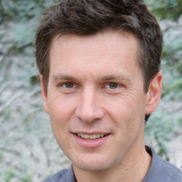 Joyful white adult male with short  brown hair and brown eyes