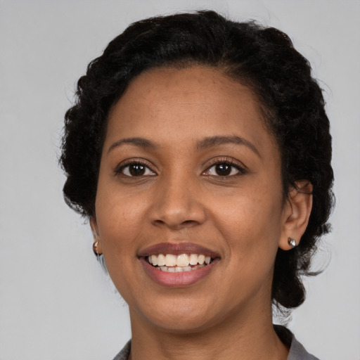 Joyful black young-adult female with short  brown hair and brown eyes