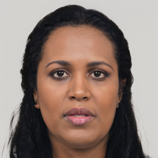 Joyful black young-adult female with long  black hair and brown eyes