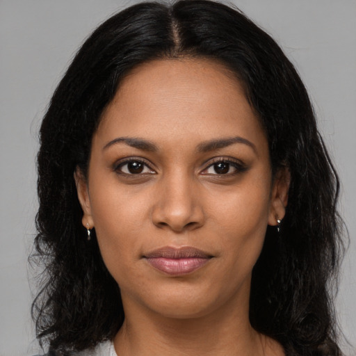 Joyful black young-adult female with long  brown hair and brown eyes