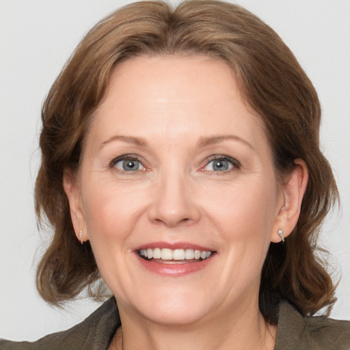 Joyful white adult female with medium  brown hair and grey eyes