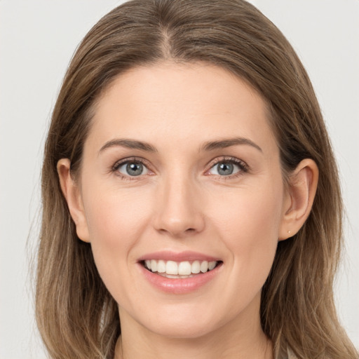 Joyful white young-adult female with long  brown hair and grey eyes