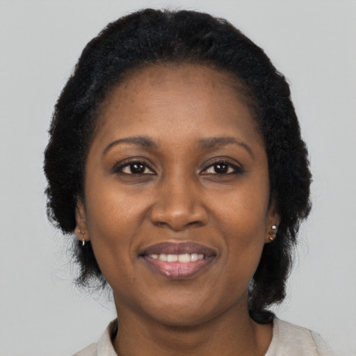 Joyful black adult female with long  black hair and brown eyes