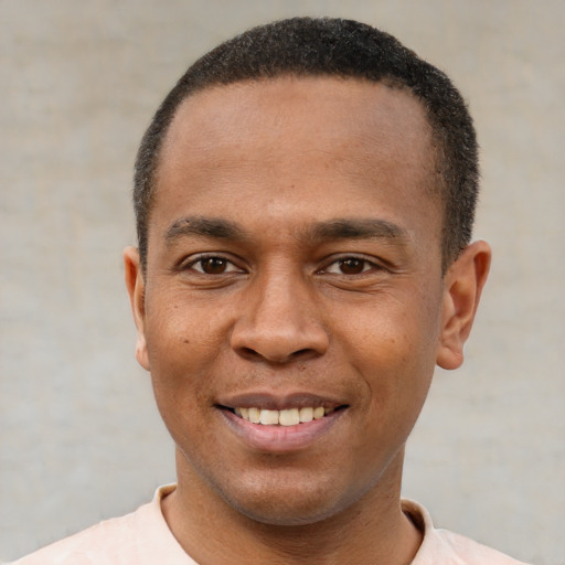 Joyful black young-adult male with short  black hair and brown eyes