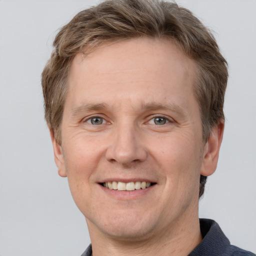 Joyful white adult male with short  brown hair and grey eyes