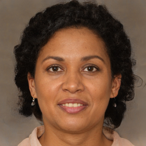 Joyful black adult female with medium  brown hair and brown eyes