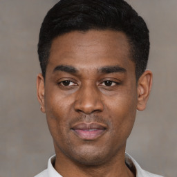 Joyful latino young-adult male with short  black hair and brown eyes