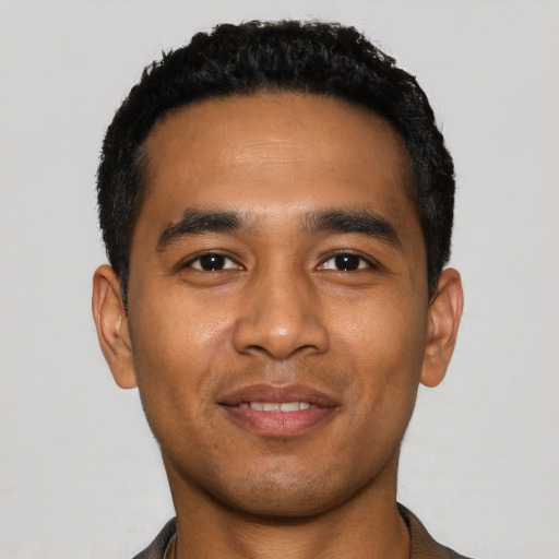Joyful latino young-adult male with short  black hair and brown eyes