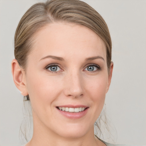 Joyful white young-adult female with medium  brown hair and grey eyes