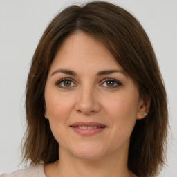 Joyful white young-adult female with medium  brown hair and green eyes