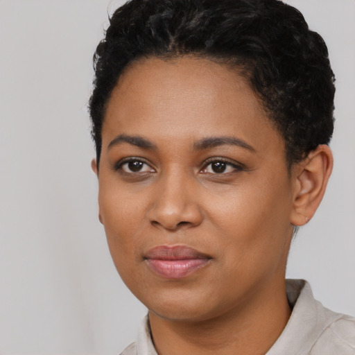 Joyful black young-adult female with short  black hair and brown eyes
