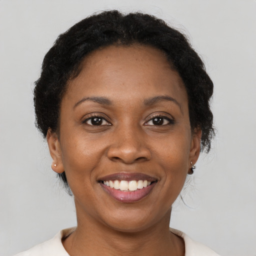 Joyful black young-adult female with short  brown hair and brown eyes