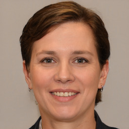 Joyful white adult female with medium  brown hair and grey eyes