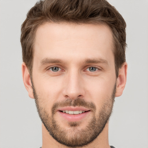 Joyful white young-adult male with short  brown hair and grey eyes