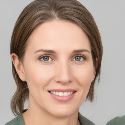 Joyful white young-adult female with medium  brown hair and grey eyes