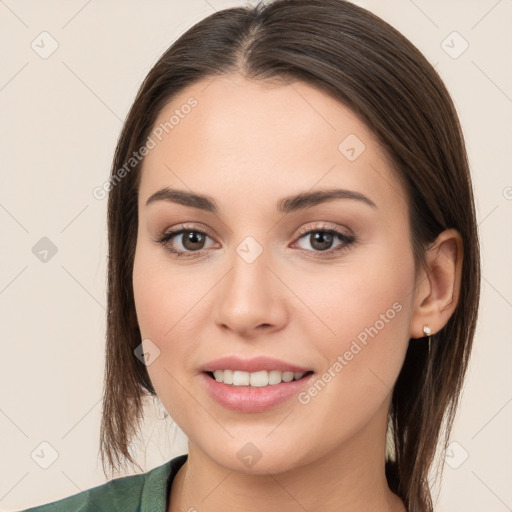 Joyful white young-adult female with long  brown hair and brown eyes