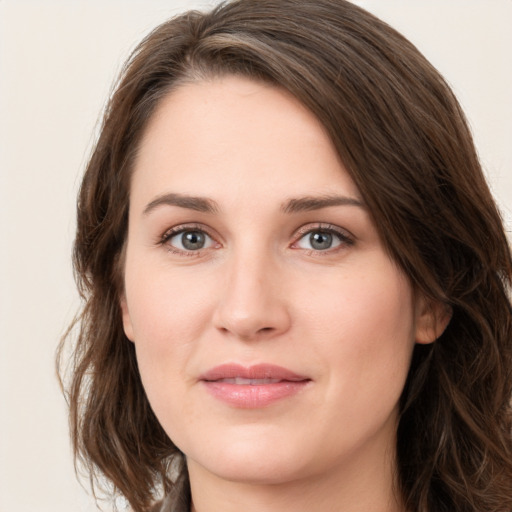 Joyful white young-adult female with long  brown hair and green eyes