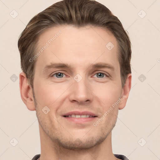 Joyful white young-adult male with short  brown hair and grey eyes