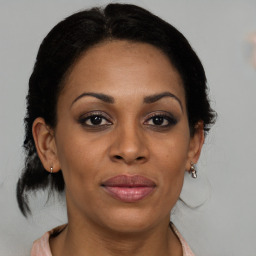 Joyful black adult female with medium  brown hair and brown eyes