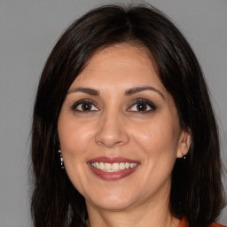 Joyful white adult female with long  brown hair and brown eyes