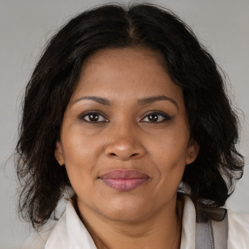 Joyful black adult female with medium  brown hair and brown eyes