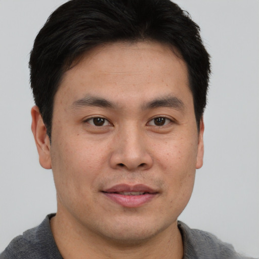 Joyful asian young-adult male with short  brown hair and brown eyes