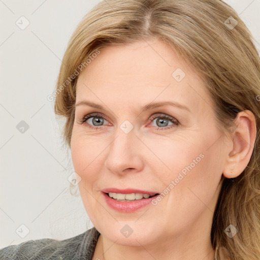 Joyful white adult female with medium  brown hair and blue eyes