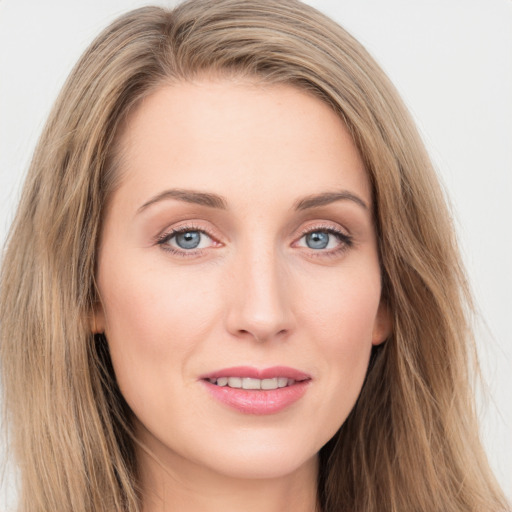 Joyful white young-adult female with long  brown hair and blue eyes