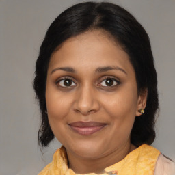 Joyful black adult female with medium  brown hair and brown eyes