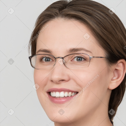 Joyful white adult female with medium  brown hair and grey eyes