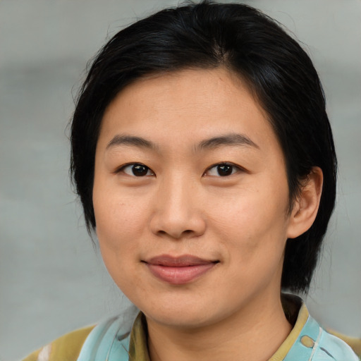 Joyful asian young-adult female with medium  brown hair and brown eyes