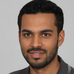 Joyful latino young-adult male with short  black hair and brown eyes