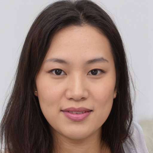 Joyful asian young-adult female with long  brown hair and brown eyes