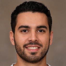 Joyful white young-adult male with short  black hair and brown eyes