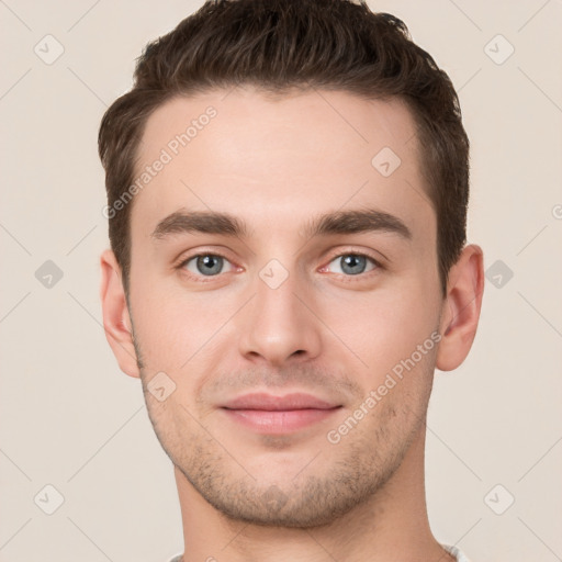 Joyful white young-adult male with short  brown hair and grey eyes