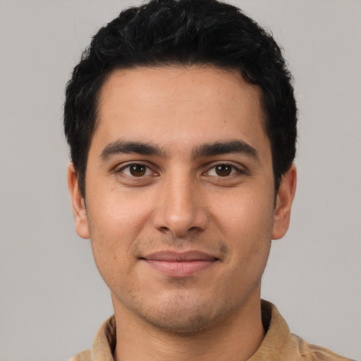 Joyful latino young-adult male with short  black hair and brown eyes