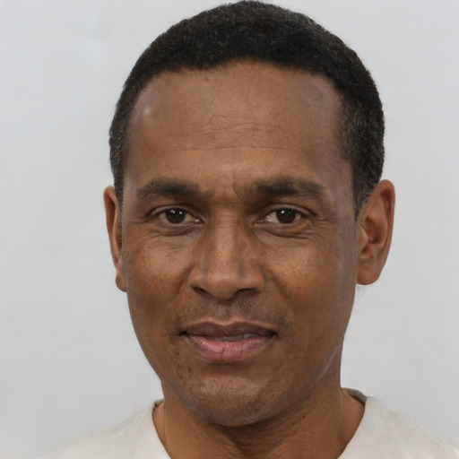 Joyful black adult male with short  black hair and brown eyes