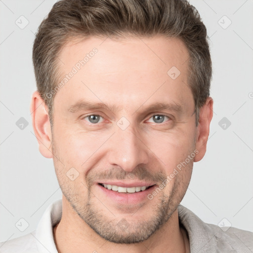 Joyful white adult male with short  brown hair and grey eyes