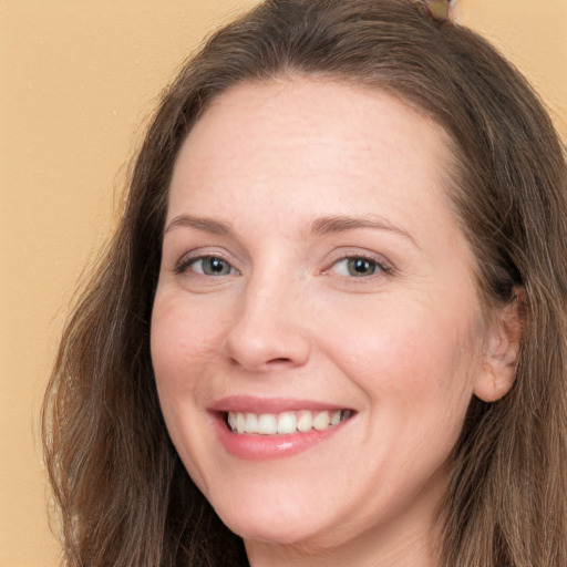 Joyful white adult female with long  brown hair and grey eyes