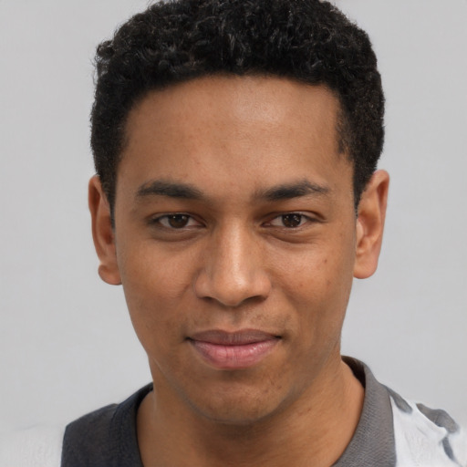 Joyful black young-adult male with short  black hair and brown eyes