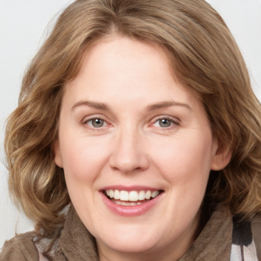 Joyful white adult female with medium  brown hair and grey eyes