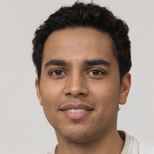 Joyful latino young-adult male with short  brown hair and brown eyes