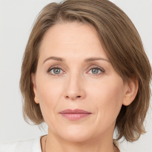 Joyful white adult female with medium  brown hair and grey eyes