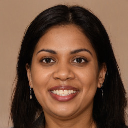 Joyful black young-adult female with long  brown hair and brown eyes