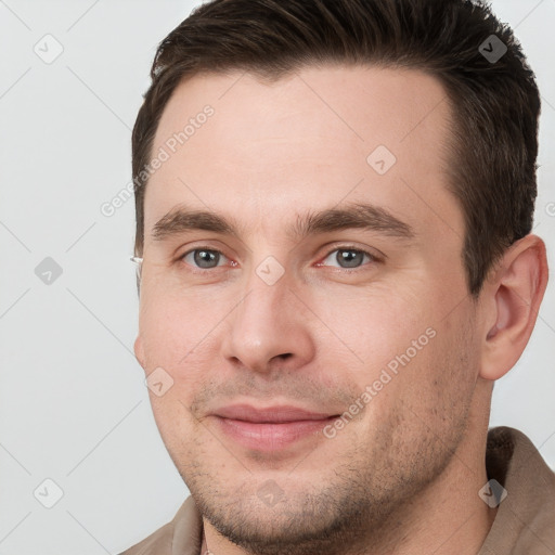 Joyful white young-adult male with short  brown hair and brown eyes