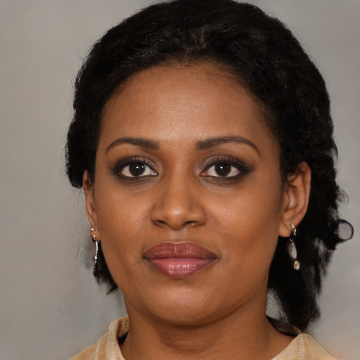 Joyful black adult female with long  brown hair and brown eyes